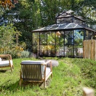 Black Janssens Kathedral orangery greenhouse in a landscaped garden