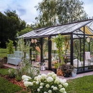 Janssens Senior black greenhouse in a landscaped garden