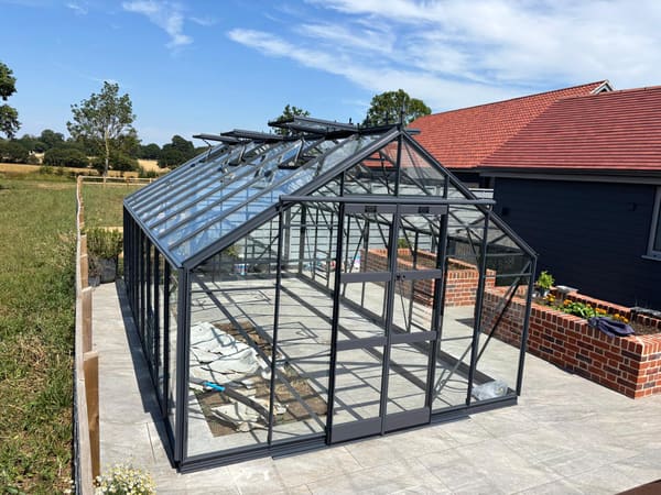 Elite Supreme 10x18 in graphite, installed alongside the house on a porcelain-tiled base.