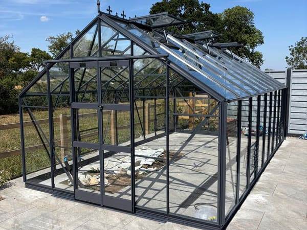 Graphite powder-coated frame with the finial and cresting fitted along the ridge.
