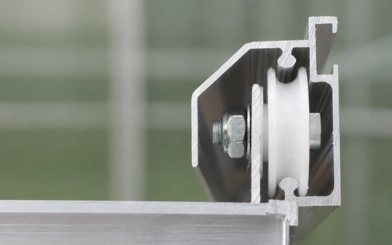 Cross-section of a genuine Elite greenhouse door wheel inside its aluminium door profile