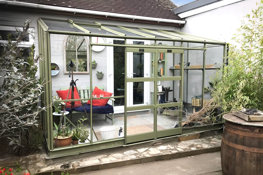 Elite Kensington 6x12 Lean to Greenhouse in olive green against a house wall